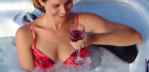 mom relaxing and drinking a wine in a hot tub