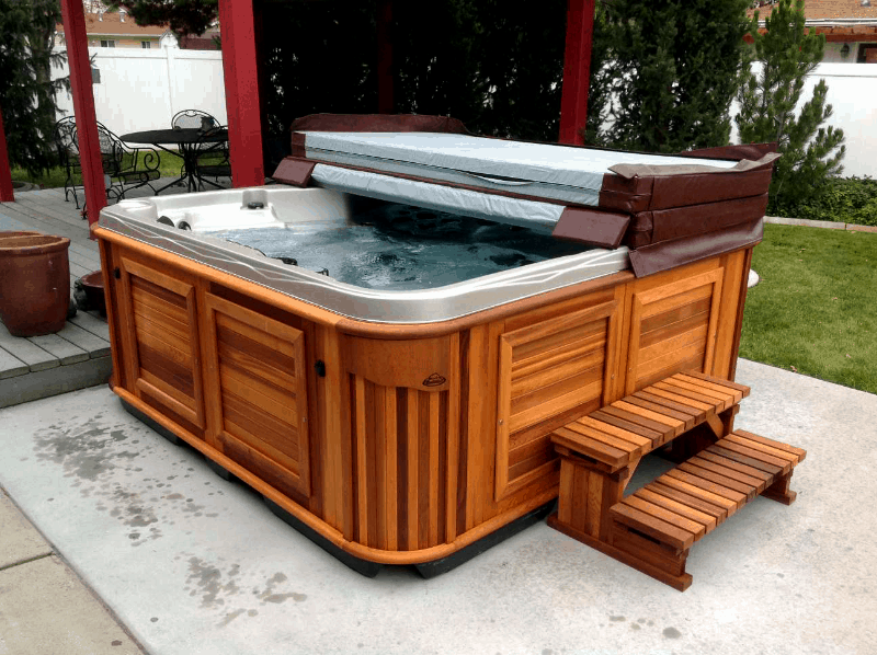 Half covered arctic spas hot tub in a backyard